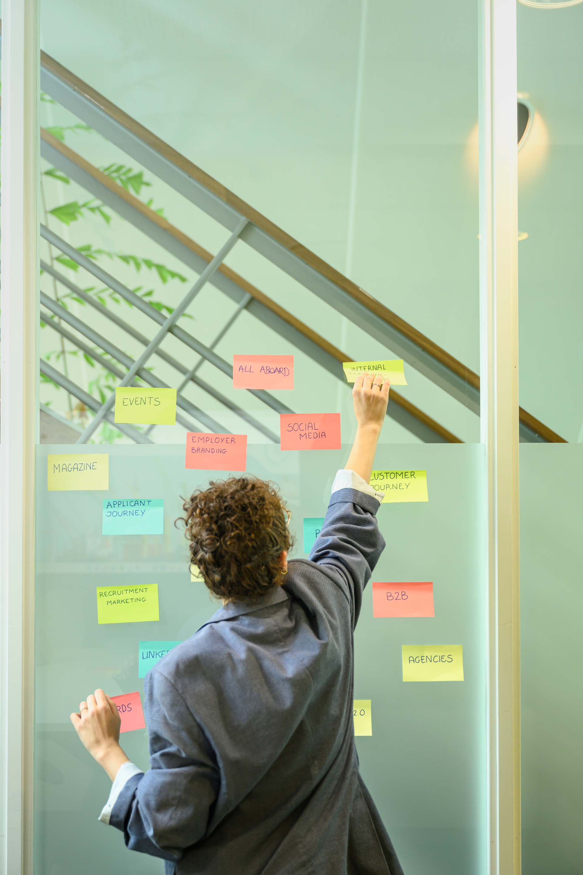 A picture of a communications officer putting up post-it notes during a brainstorming session.